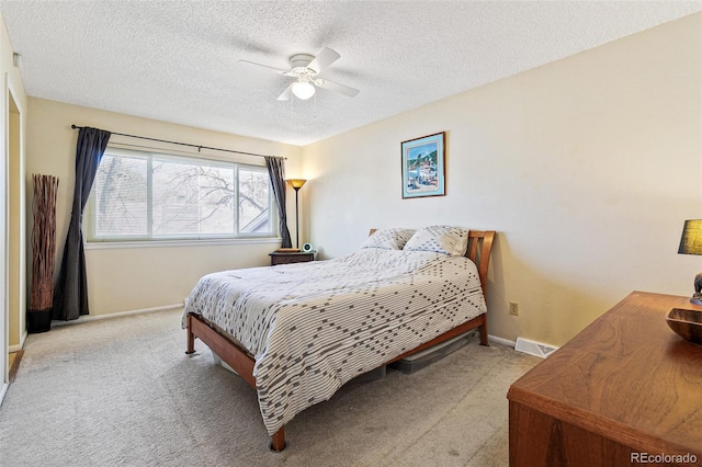 bedroom with a textured ceiling, ceiling fan, carpet, and baseboards