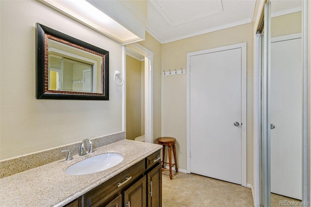 bathroom with tile patterned flooring, crown molding, vanity, and baseboards