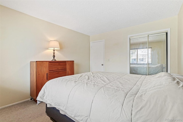 bedroom featuring a closet, carpet flooring, a textured ceiling, and baseboards