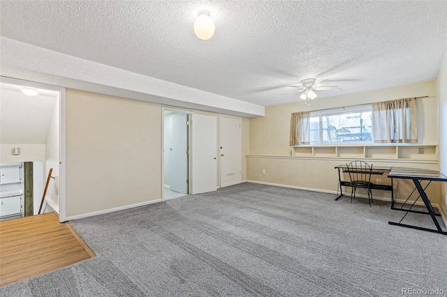 interior space with carpet, ceiling fan, a textured ceiling, and baseboards