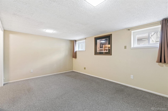 basement featuring carpet, baseboards, and a textured ceiling