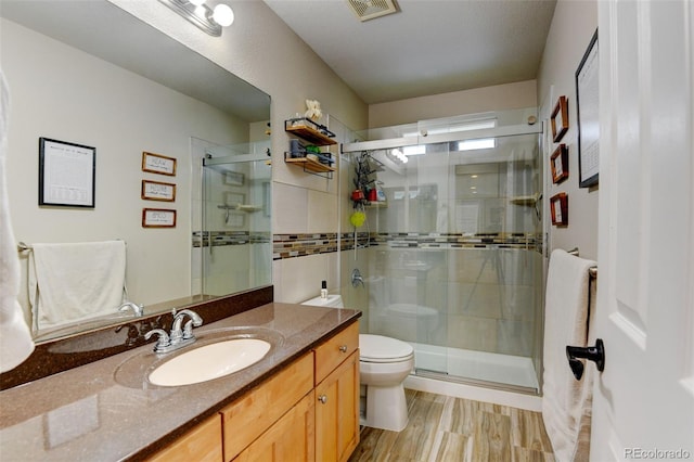 1995 E 166th Ave, Thornton, CO 80602 - full bath featuring toilet, vanity, a shower stall, and wood finished floors