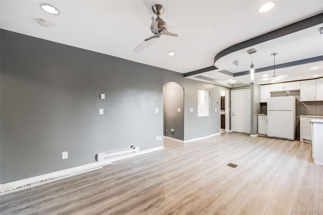 unfurnished living room featuring ceiling fan, a baseboard heating unit, and light hardwood / wood-style floors