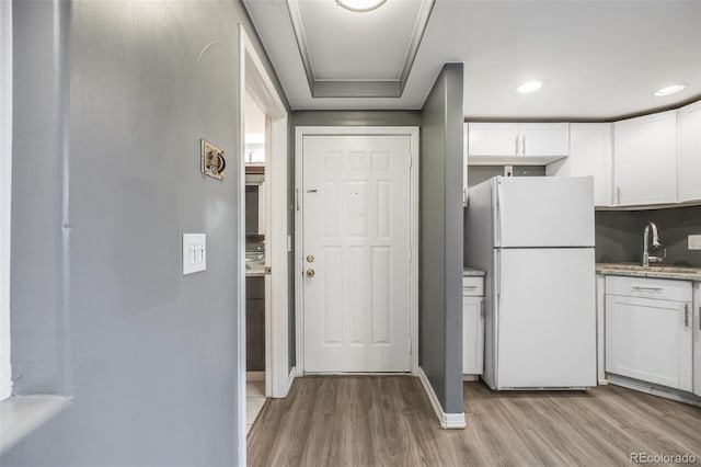 kitchen featuring light hardwood / wood-style floors, white cabinets, and white refrigerator