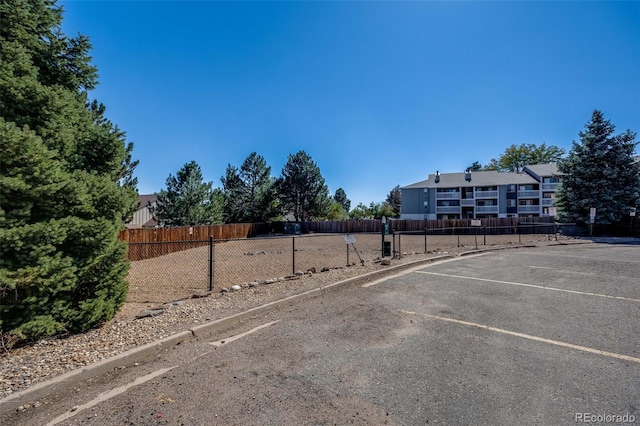 uncovered parking lot featuring fence