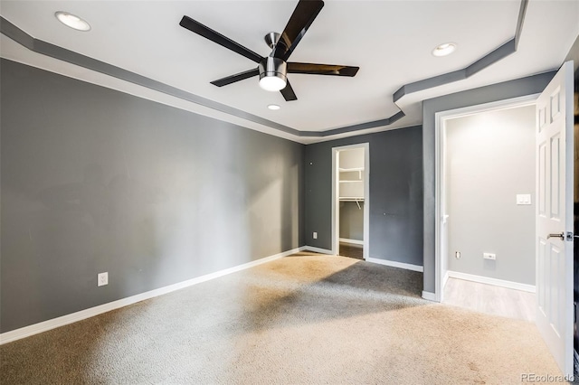 unfurnished bedroom featuring baseboards, a walk in closet, a ceiling fan, and recessed lighting