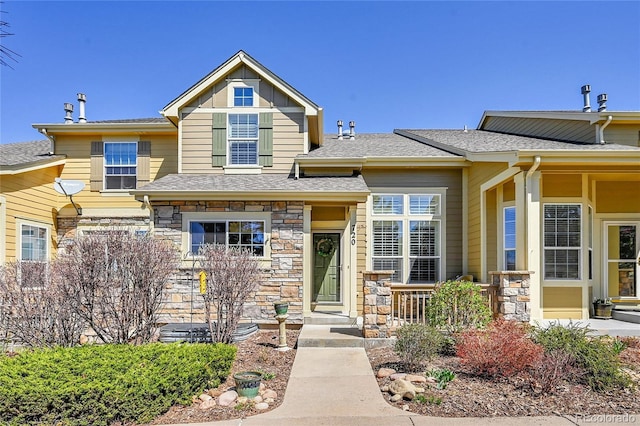 view of front of house featuring a shingled roof and stone siding