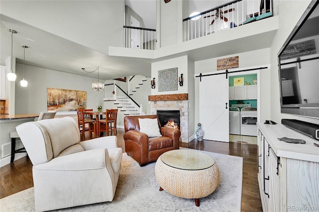 living room with baseboards, washing machine and dryer, dark wood-style floors, and stairs