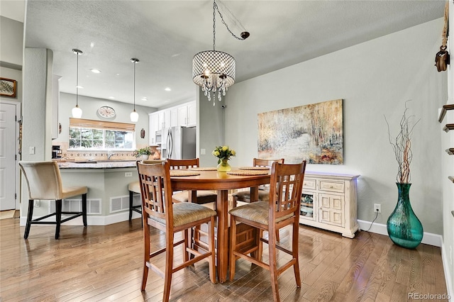 dining room featuring baseboards, recessed lighting, a chandelier, and hardwood / wood-style flooring