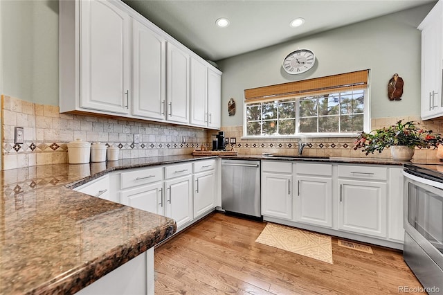 kitchen with white cabinetry, appliances with stainless steel finishes, a sink, and recessed lighting