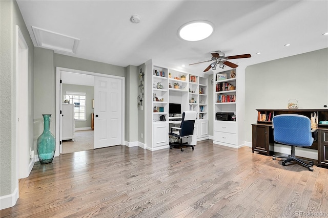 office space featuring attic access, a ceiling fan, and wood finished floors