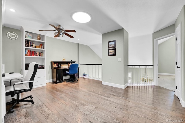 office area with baseboards, ceiling fan, built in shelves, and wood finished floors