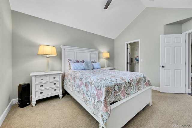 carpeted bedroom with a closet, lofted ceiling, baseboards, a walk in closet, and ceiling fan