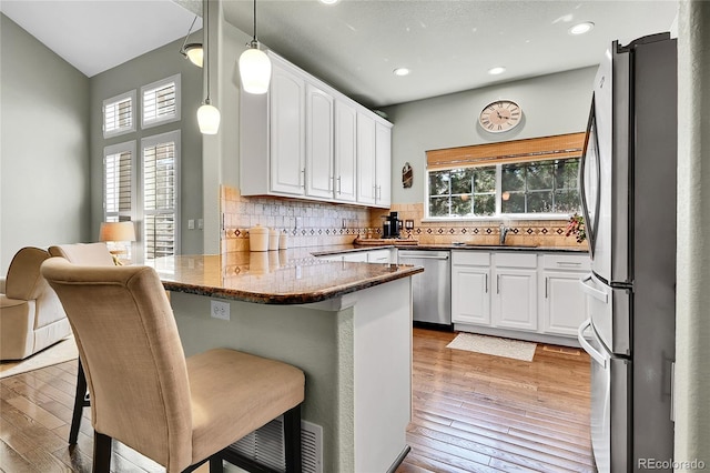 kitchen with a sink, white cabinetry, appliances with stainless steel finishes, and a wealth of natural light