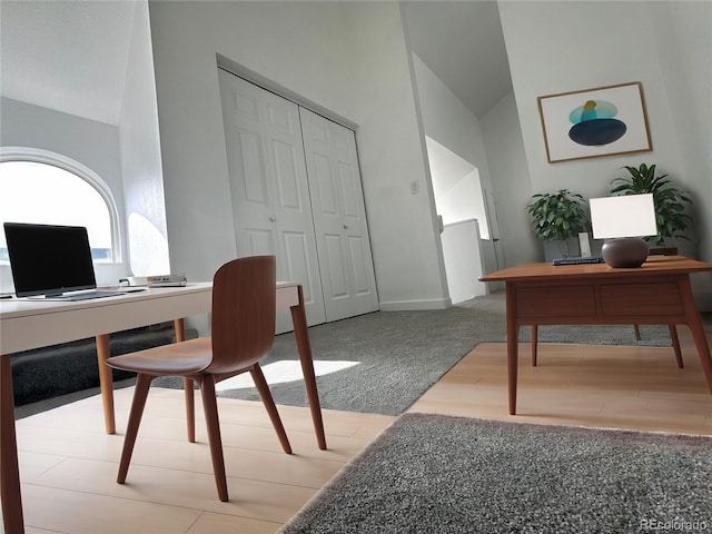 home office featuring high vaulted ceiling, wood finished floors, carpet flooring, and baseboards