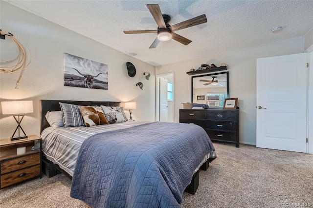 bedroom featuring ceiling fan, a textured ceiling, and light carpet