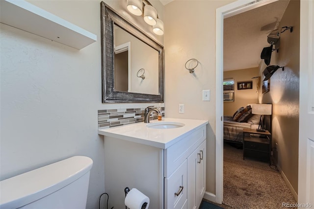 bathroom with a textured ceiling, vanity, toilet, and tasteful backsplash