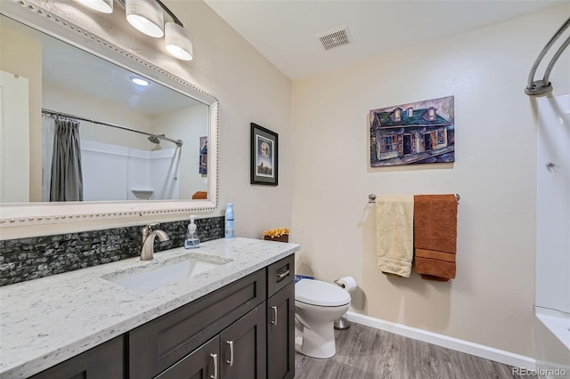 full bathroom featuring shower / bath combination with curtain, vanity, wood-type flooring, backsplash, and toilet