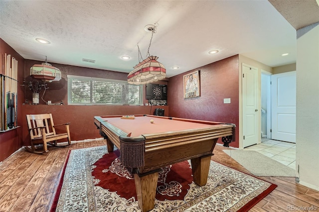 recreation room with light hardwood / wood-style floors, billiards, and a textured ceiling