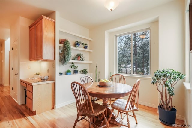 dining area with light wood-style flooring and baseboards