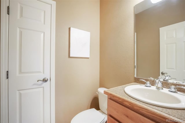 bathroom featuring toilet and vanity