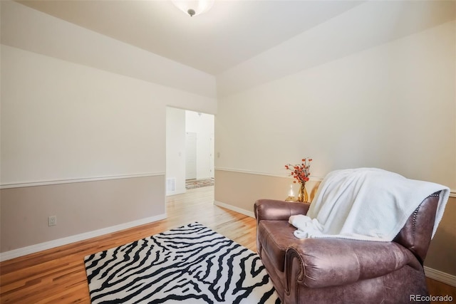 living area featuring visible vents, light wood-style flooring, and baseboards