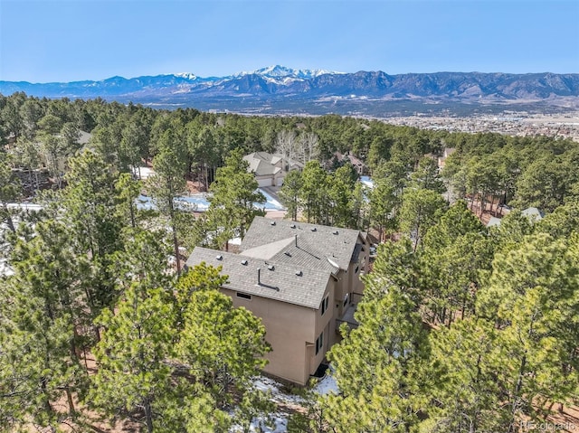 birds eye view of property featuring a mountain view and a wooded view