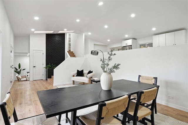dining area featuring stairs, light wood-style flooring, baseboards, vaulted ceiling, and recessed lighting