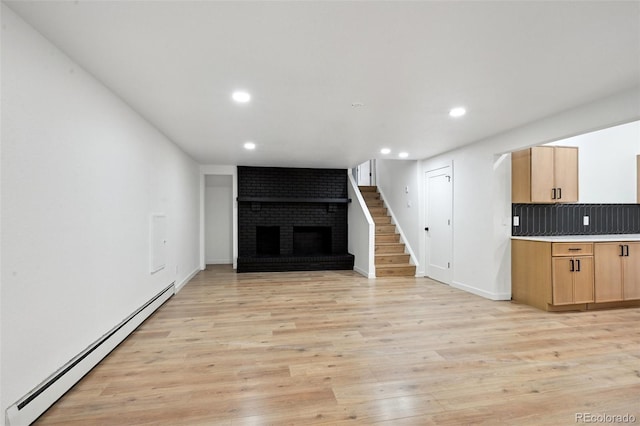 unfurnished living room with a baseboard radiator, a fireplace, recessed lighting, stairway, and light wood-type flooring