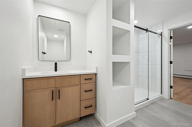 bathroom with a stall shower, vanity, and wood finished floors