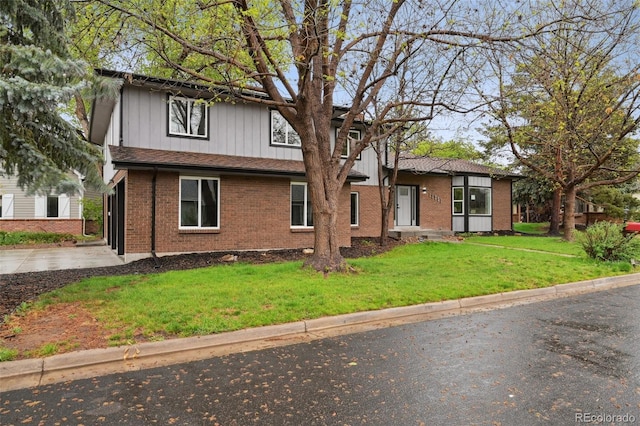 traditional-style house with brick siding and a front lawn
