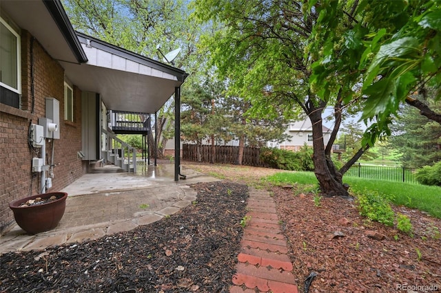 view of yard featuring fence, a patio, and stairway
