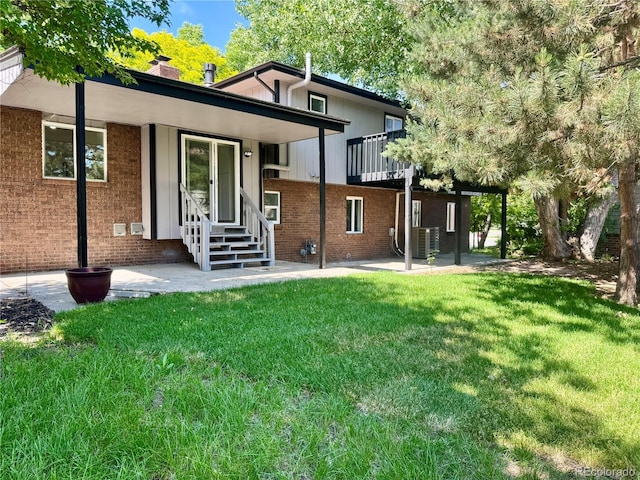 11351 Quivas Way, Denver, CO 80234 - back of house featuring brick siding, a lawn, a patio, and entry steps