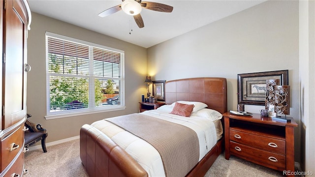 bedroom featuring light colored carpet, ceiling fan, and baseboards