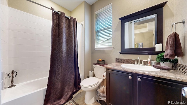 bathroom featuring a textured wall, vanity, toilet, and shower / bath combo with shower curtain