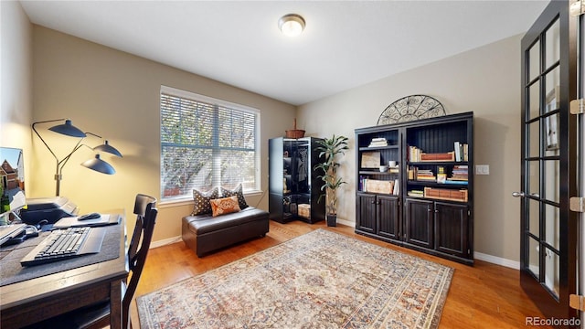 home office featuring light wood-type flooring and baseboards