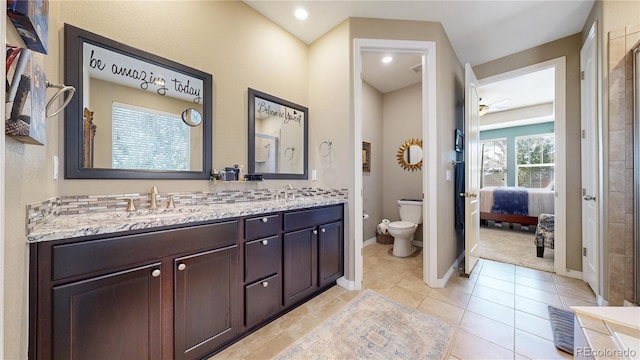 full bathroom with double vanity, toilet, a sink, and ensuite bathroom