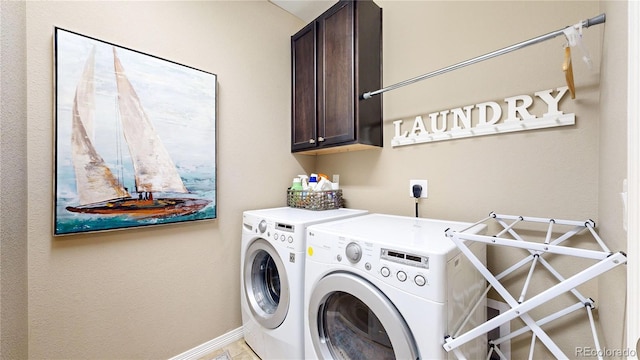 laundry area featuring cabinet space, washing machine and dryer, and baseboards