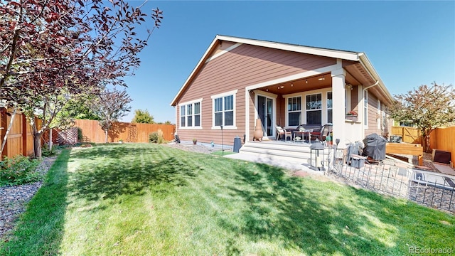 rear view of property featuring a patio area, a fenced backyard, and a lawn