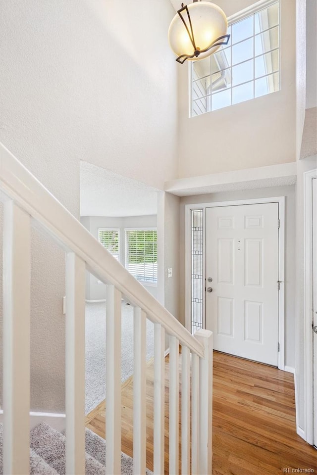 9823 Salford Ln, Highlands Ranch, CO 80126 - foyer with a chandelier, a towering ceiling, wood finished floors, and stairs