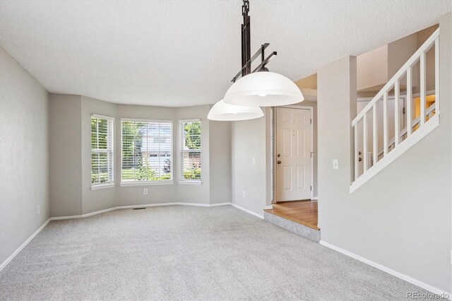 9823 Salford Ln, Highlands Ranch, CO 80126 - unfurnished room featuring carpet flooring, stairway, and a textured ceiling