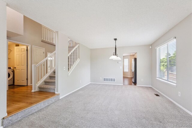 9823 Salford Ln, Highlands Ranch, CO 80126 - carpeted spare room featuring washer / clothes dryer, a textured ceiling, and stairway