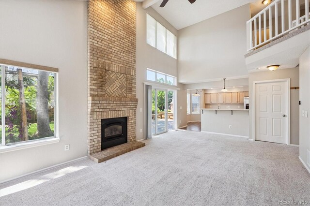 9823 Salford Ln, Highlands Ranch, CO 80126 - unfurnished living room featuring a towering ceiling, ceiling fan, carpet flooring, and a fireplace