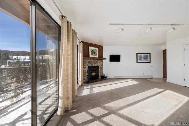 unfurnished living room with a mountain view, carpet, a fireplace, and baseboard heating