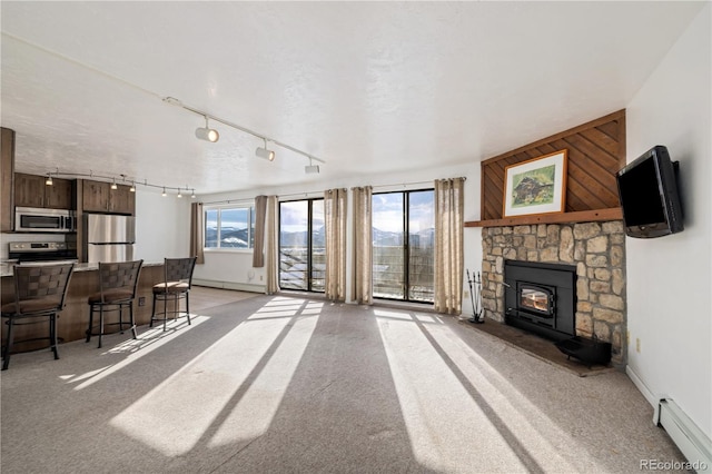 carpeted living room featuring a baseboard radiator and a textured ceiling