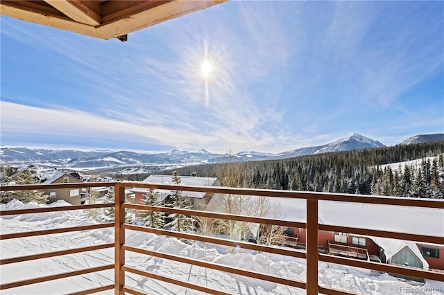 snow covered back of property with a mountain view