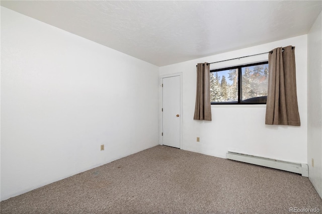 carpeted spare room with a baseboard heating unit