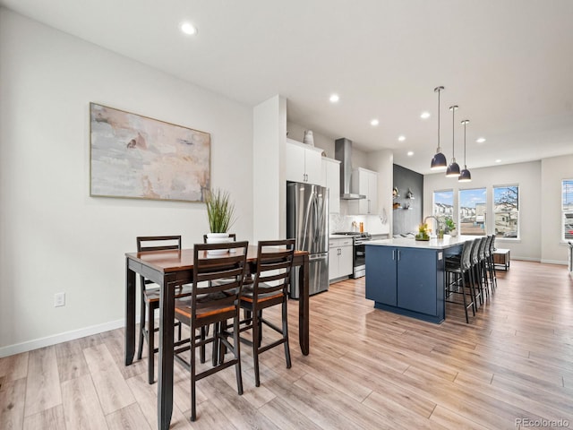 dining area with light wood-type flooring, baseboards, and recessed lighting