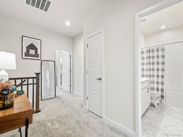 hall with baseboards, visible vents, and recessed lighting