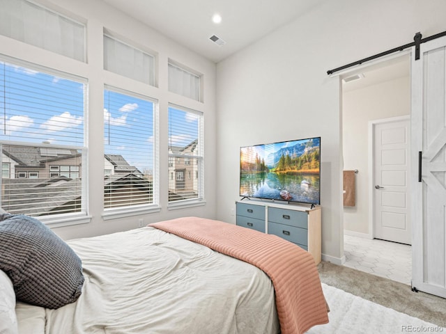 bedroom with visible vents, a barn door, baseboards, light colored carpet, and recessed lighting